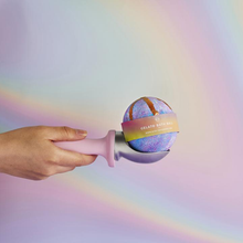 Load image into Gallery viewer, Miss Patisserie gelato bath ball. Image shows the bath ball sitting whimsically on an ice cream scoop, with a bright and colourful background. Vegan and cruelty-free. Available at Lovethical along with plenty of other vegan and cruelty-free beauty products, makeup, make up, toiletries and cosmetics for all your gift and present needs. 
