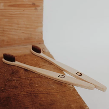 Load image into Gallery viewer, Moonie bamboo toothbrush. Vegan, cruelty-free and plastic-free. Available at Lovethical along with plenty of other vegan and cruelty-free beauty products, makeup, make up, toiletries and cosmetics for all your gift and present needs. 
