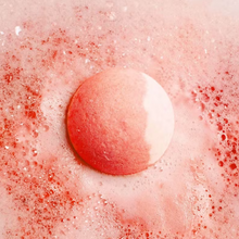 Load image into Gallery viewer, Bubble T Cosmetics peach bath bomb. Image shows the bath bomb in water surrounded by lovely peach-coloured water and bubbles. Vegan and cruelty-free. Available at Lovethical along with plenty of other vegan and cruelty-free beauty products, makeup, make up, toiletries and cosmetics for all your gift and present needs.
