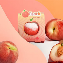 Load image into Gallery viewer, Bubble T Cosmetics peach bath bomb. Image shows the bath bomb in its packaging and surrounded by peaches. Vegan and cruelty-free. Available at Lovethical along with plenty of other vegan and cruelty-free beauty products, makeup, make up, toiletries and cosmetics for all your gift and present needs.
