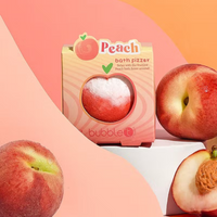 Bubble T Cosmetics peach bath bomb. Image shows the bath bomb in its packaging and surrounded by peaches. Vegan and cruelty-free. Available at Lovethical along with plenty of other vegan and cruelty-free beauty products, makeup, make up, toiletries and cosmetics for all your gift and present needs.