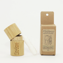 Load image into Gallery viewer, Flawless compostable dental floss with bamboo dispenser - peppermint. Image shows the bamboo dispenser, the corn fibre dental floss, and its cardboard packaging alongside it. Vegan and cruelty-free. Available at Lovethical along with plenty of other vegan and cruelty-free beauty products, makeup, make up, toiletries and cosmetics for all your gift and present needs. 
