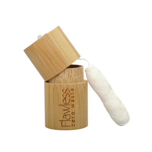 Flawless compostable dental floss with bamboo dispenser - peppermint. Image shows the bamboo dispenser and the corn fibre floss alongside it. Vegan and cruelty-free. Available at Lovethical along with plenty of other vegan and cruelty-free beauty products, makeup, make up, toiletries and cosmetics for all your gift and present needs. 