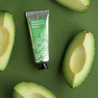 Image of Fruu's almighty avocado balm surrounded by bits of cut up avocado and a vibrant green background. Vegan and cruelty-free. Available at Lovethical along with plenty of other vegan and cruelty-free beauty products, makeup, make up, toiletries and cosmetics for all your gift and present needs. 