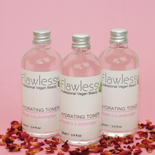 Load image into Gallery viewer, 3 glass bottles of Flawless hydrating toner - rose and lavender - stood next to each other with bits of rose petals under them. Vegan and cruelty-free. Available at Lovethical along with plenty of other vegan and cruelty-free beauty products, makeup, make up, toiletries and cosmetics for all your gift and present needs. 
