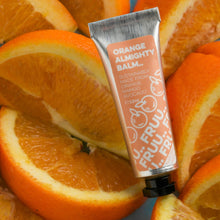 Load image into Gallery viewer, Picture of Fruu&#39;s almighty orange balm in front of lots of slices of oranges. Vegan and cruelty-free. Available at Lovethical along with plenty of other vegan and cruelty-free beauty products, makeup, make up, toiletries and cosmetics for all your gift and present needs. 
