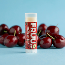 Load image into Gallery viewer, Fruu cherry lip balm. Picture shows the balm along with some cherries. Vegan and cruelty-free. Available at Lovethical along with plenty of other vegan and cruelty-free beauty products, makeup, make up, toiletries and cosmetics for all your gift and present needs. 
