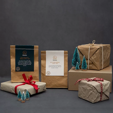 Load image into Gallery viewer, Moonie eco grooming gift set. Vegan and cruelty-free. Image shows the gift set alongside Christmassy wrapped presents. Available at Lovethical along with plenty of other vegan and cruelty-free beauty products, makeup, make up, toiletries and cosmetics for all your gift and present needs. 
