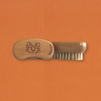 Moonie nail brush. Vegan and cruelty-free. Image shows the nail brush with the image of a smiling crab on the top. Available at Lovethical along with plenty of other vegan and cruelty-free beauty products, makeup, make up, toiletries and cosmetics for all your gift and present needs. 
