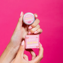 Load image into Gallery viewer, Pura Cosmetics pink tinted lip balm. Vegan and cruelty-free. Image shows a person holding the lip balm and its outer packaging. Available at Lovethical along with plenty of other vegan and cruelty-free beauty products, makeup, make up, toiletries and cosmetics for all your gift and present needs. 
