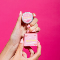 Pura Cosmetics pink tinted lip balm. Vegan and cruelty-free. Image shows a person holding the lip balm and its outer packaging. Available at Lovethical along with plenty of other vegan and cruelty-free beauty products, makeup, make up, toiletries and cosmetics for all your gift and present needs. 