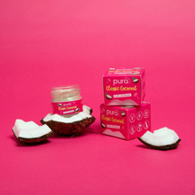 Load image into Gallery viewer, Glass pot of Pura Cosmetics classic coconut lip scrub. Image shows the product both boxed and unboxed, with pieces of coconut next to them. Vegan and cruelty-free. Available at Lovethical along with plenty of other vegan and cruelty-free beauty products, makeup, make up, toiletries and cosmetics for all your gift and present needs. 
