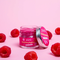 Pura Cosmetics raspberry and forest fruits lip scrub and balm duo gift set. Vegan and cruelty-free. Image shows an open pot of the raspberry lip scrub surrounded by fruit. Available at Lovethical along with plenty of other vegan and cruelty-free beauty products, makeup, make up, toiletries and cosmetics for all your gift and present needs. 