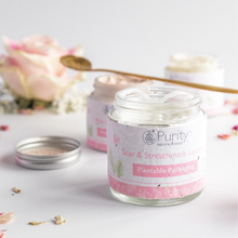 Load image into Gallery viewer, Beautiful picture of an open pot of Purity&#39;s Scar and Stretchmark Lotion with flowers in the background. Vegan and cruelty-free. Available at Lovethical along with plenty of other vegan and cruelty-free beauty products, makeup, make up, toiletries and cosmetics for all your gift and present needs. 
