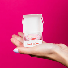 Load image into Gallery viewer, Pura Cosmetics pink tinted lip balm. Vegan and cruelty-free. Image shows a person holding the lip balm in their hand. Available at Lovethical along with plenty of other vegan and cruelty-free beauty products, makeup, make up, toiletries and cosmetics for all your gift and present needs. 
